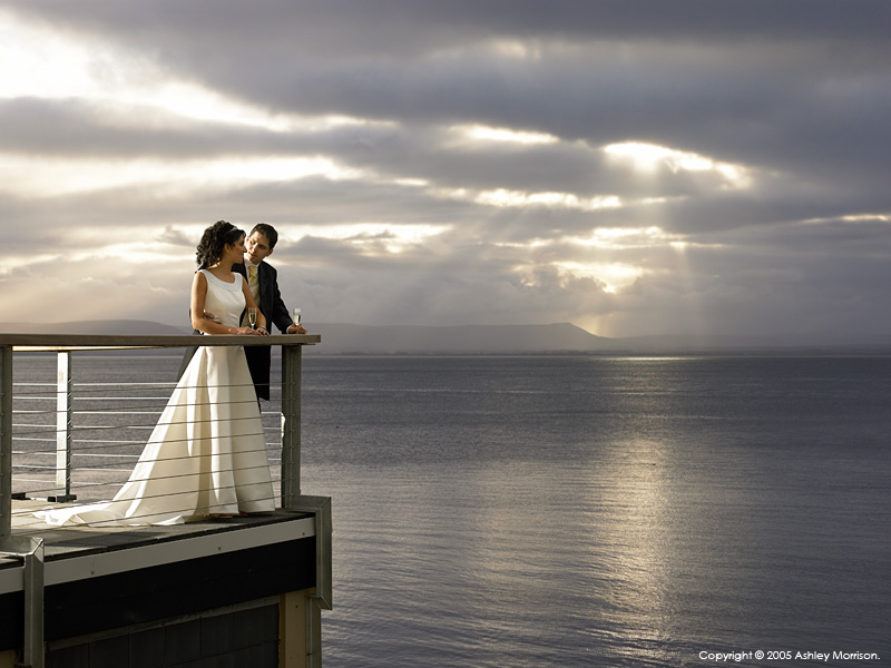 Bride & Groom standing out on the balcony at the Redcastle Hotel near the town of Moville on the Inishowen Peninsula of County Donegal.
